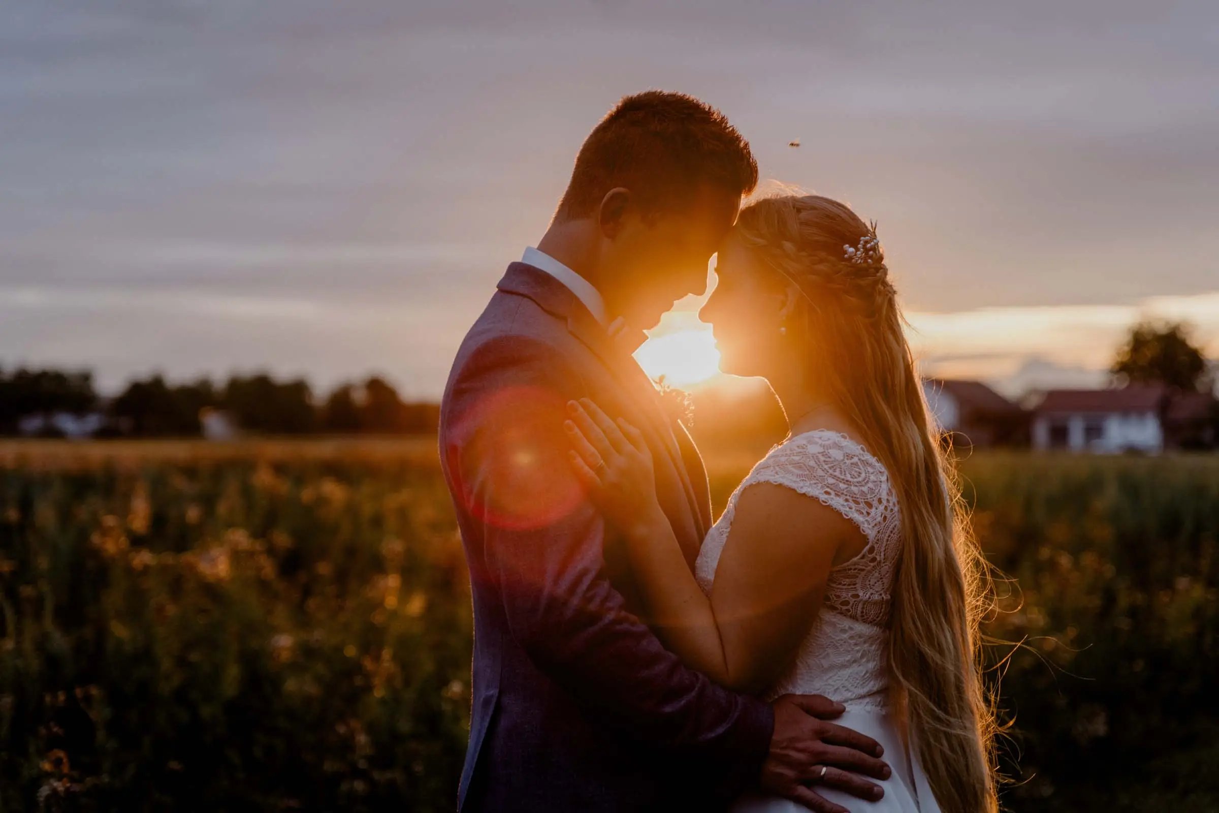 Hochzeitsfoto von Braut und Bräutigam in der Sonne in Hochzeitskleid Augsburg