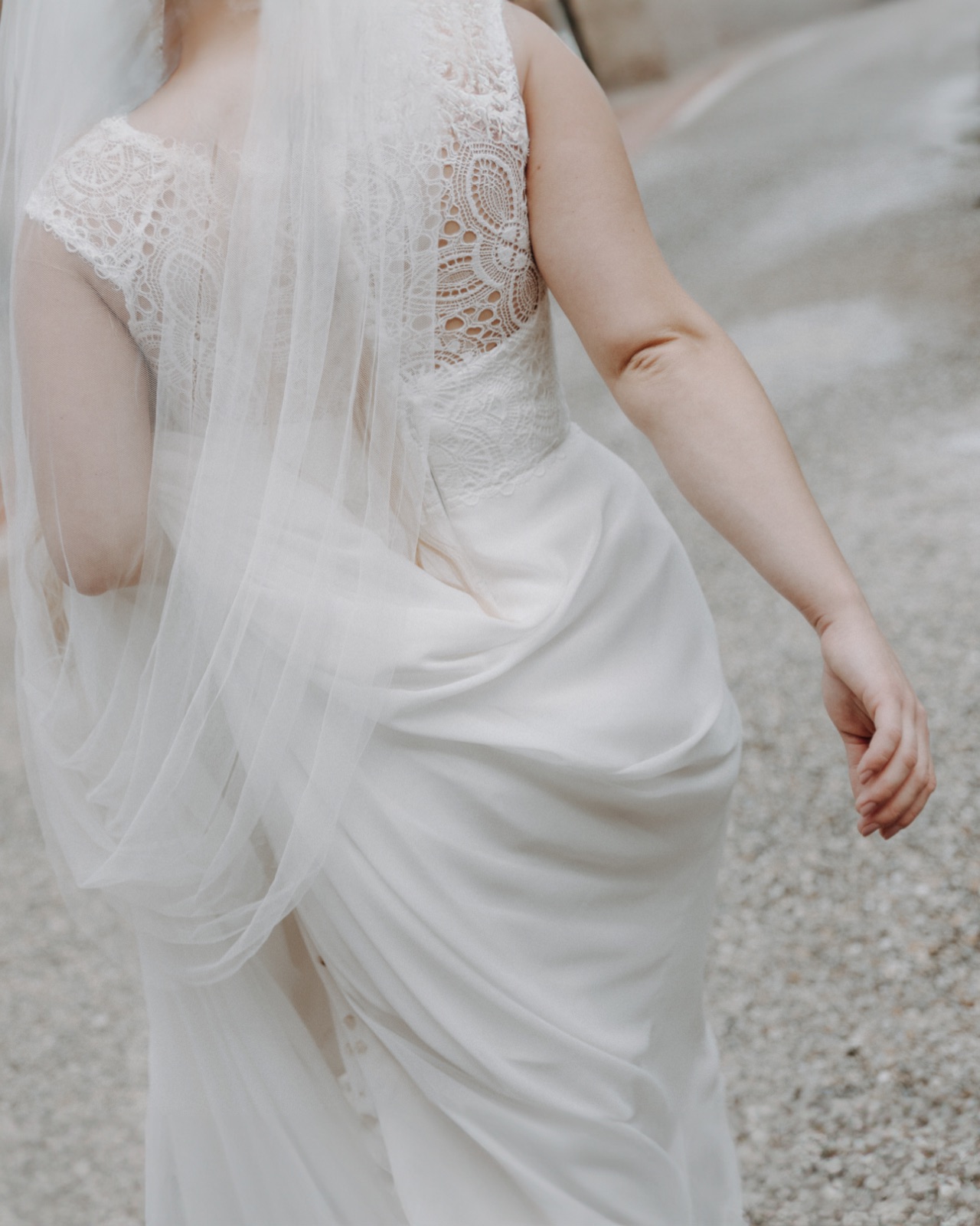 Nahaufnahme von Spitze und Schleier am Rücken des Brautkleids, Teil der Getting Ready Fotos zur Hochzeit.